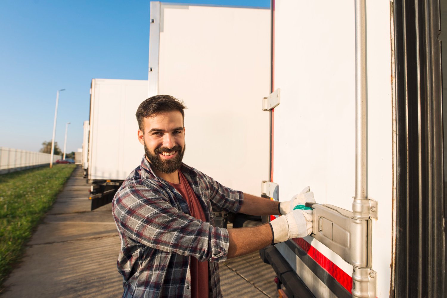 moving company worker smiles and closes the door of truck