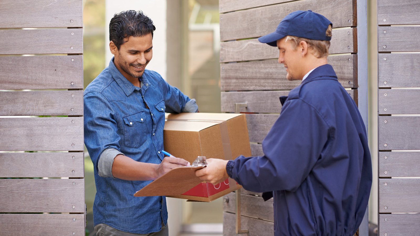 Delivery with a smile. A friendly delivery man delivering a pack