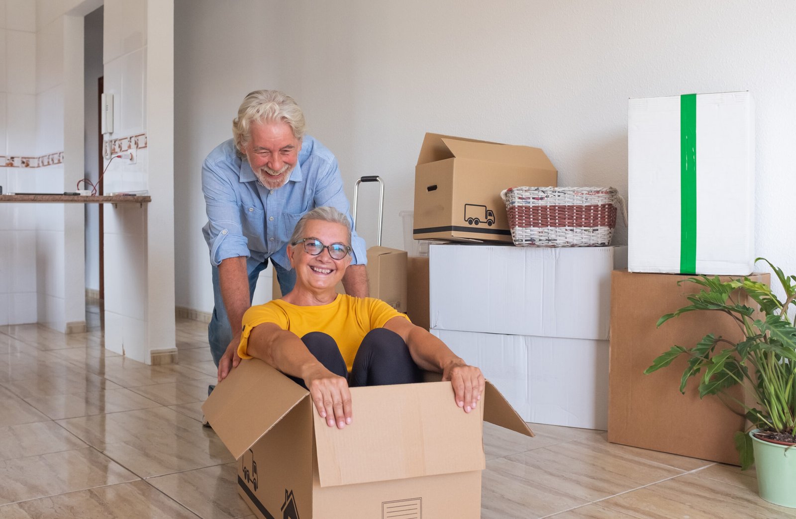Happy senior couple white haired having fun during relocation